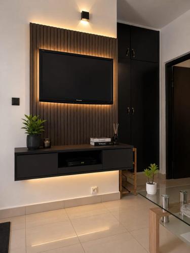 a living room with a television on a wall at HAPPY WELCOME Biétry 3 - MARCORY ZONE 4 in Abidjan