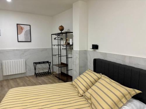 a bedroom with a bed with a yellow and white striped pillow at URDAIHOME SUITES & BIKEs in Guernica y Luno