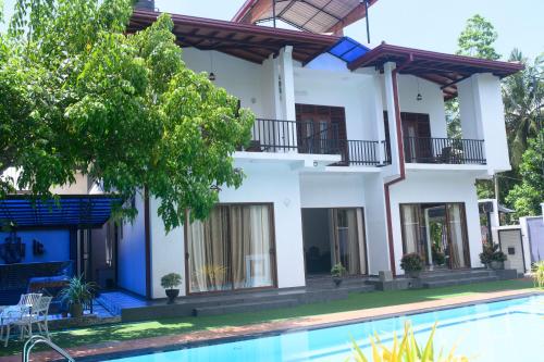 a house with a swimming pool in front of it at Madu Rivora Villa in Ambalangoda