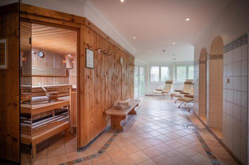 un bagno con pareti in legno, tavoli e sedie di by franz - Alpine Apartments in Kirchberg a Kirchberg in Tirol