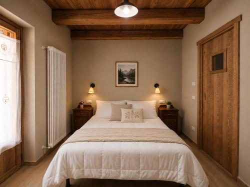 a bedroom with a large bed with two night stands at Appartamento Alta Valle Maira - Tibert in Ponte Maira