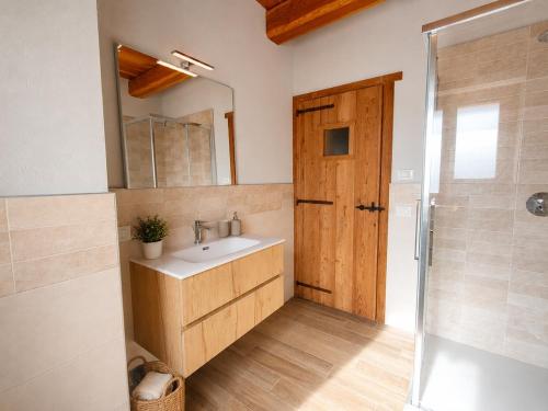 a bathroom with a sink and a mirror and a shower at Appartamento Alta Valle Maira - Tibert in Ponte Maira