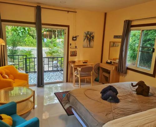 a bedroom with a bed and a living room at Blue Cottage Koh Kood a Quiet Tropical Getaway in Ban Lak Uan