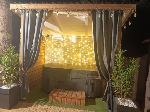 an outdoor shower with a curtain and lights at Chalet Les Buis in Saint-Paul-lès-Romans
