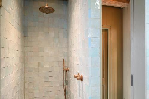 a bathroom with a shower with white tiles at Walingsuites in Holwerd