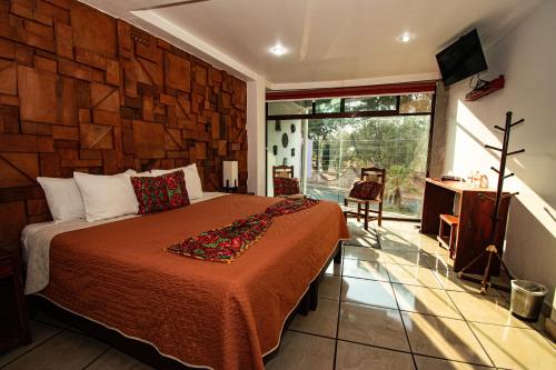 a bedroom with a bed with a wooden wall at Hotel Boutique Acocalli in San Juan Teotihuacán