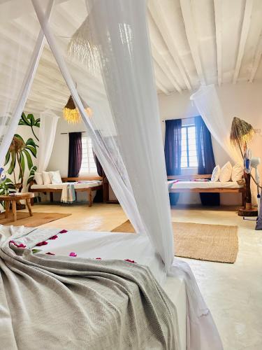 a bedroom with a bed with a mosquito net at Garden Beach Bungalows Jambiani in Jambiani