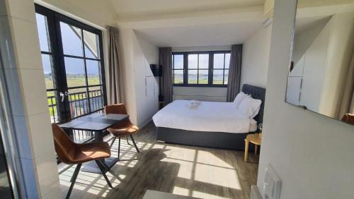 a bedroom with a bed and a table and chairs at Sientjes Boetiekhotel in Kerkdriel