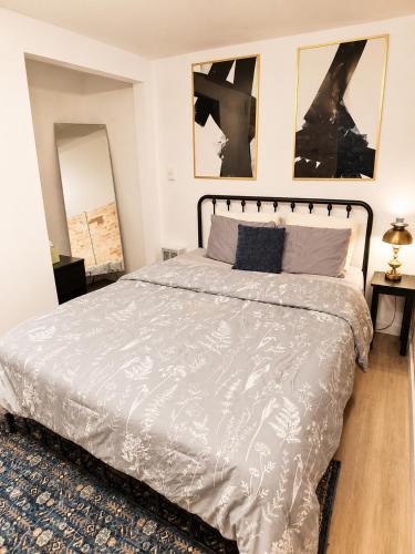 a bedroom with a bed and two pictures on the wall at Downtown Detroit Hidden Gem Walk to Venues & DMC in Detroit