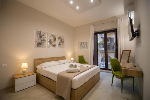 a bedroom with a bed and a desk and a window at Athenèa Smart Rooms - Atenea Collection in Agrigento