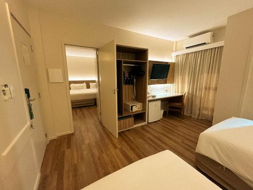 a hotel room with a bed and a desk at Quality Hotel Aracaju in Aracaju
