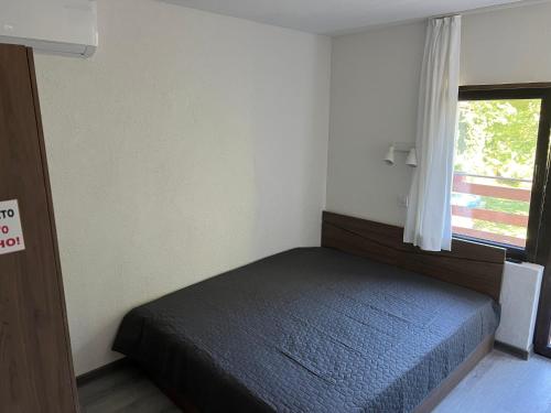 a small bedroom with a bed with a window at Къща за гости Зафирови in Ribarica