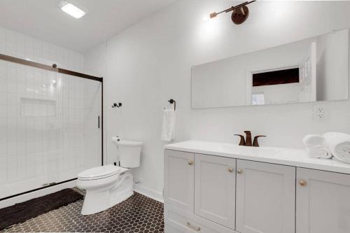 a white bathroom with a toilet and a sink at The Neuschwanstein Flat- Walkable in Columbus