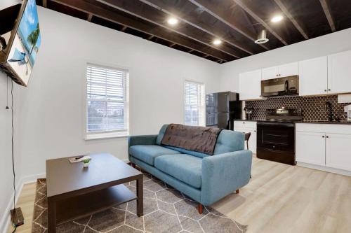 a living room with a blue couch and a kitchen at The Neuschwanstein Flat- Walkable in Columbus