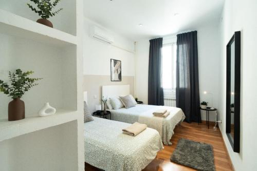 a hotel room with two beds and a window at Magdalena2 Street, Private rooms in Madrid