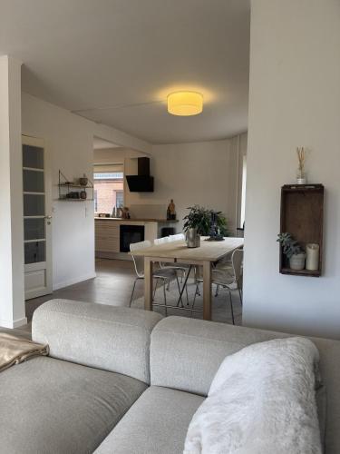 a living room with a couch and a table and a kitchen at Hygge Home Aalborg, Free Parking & 15 Min to City Centre in Nørresundby