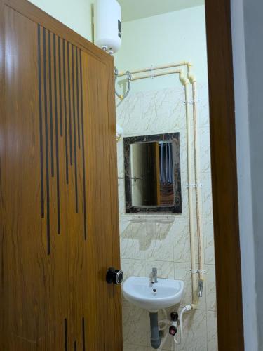 a bathroom with a sink and a wooden door at walking distance from temble in Guruvāyūr