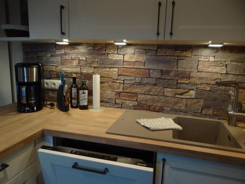 a kitchen counter with a sink and a brick wall at Darssblick Barth - Boddenblick, Tiefgarage & Aufzug in Barth