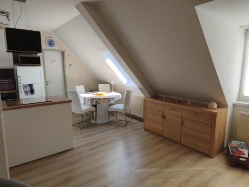 a kitchen and dining room with a table in a attic at Darssblick Barth - Boddenblick, Tiefgarage & Aufzug in Barth
