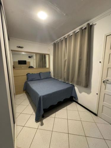 a bedroom with a bed in a room with a window at Espaço rosa mar in Aracaju