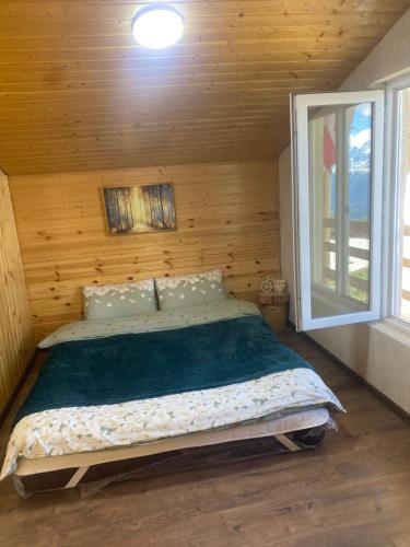 a bedroom with a bed in a wooden cabin at სასტუმრო ქორულდი / Hotel Koruldi in Mestia