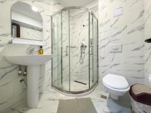 a bathroom with a shower and a sink and a toilet at Pensiunea Riviera in Costinesti