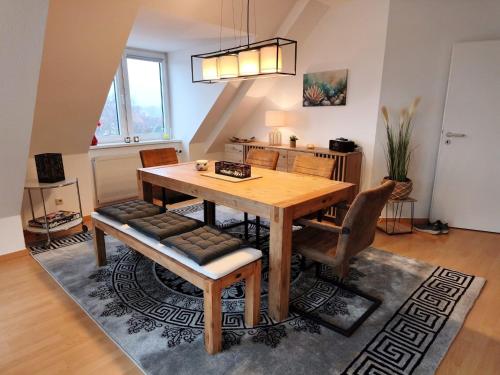 a dining room with a wooden table and chairs at Traumblick Barth - Boddenblick, Tiefgarage & Aufzug in Barth