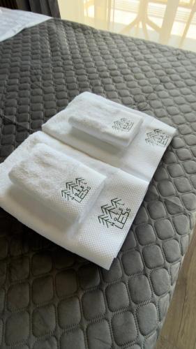 two towels sitting on top of a bed at LESS HOTEL Затока in Zatoka
