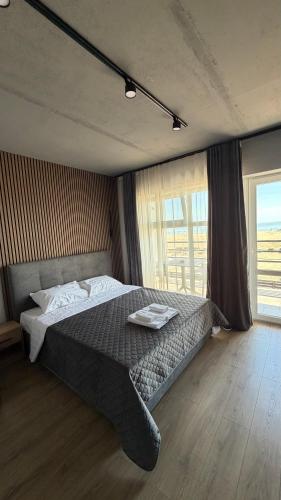 a bedroom with a bed and a large window at LESS HOTEL Затока in Zatoka