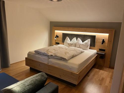 a bedroom with a large bed with a wooden headboard at Schererhof in Rimsting