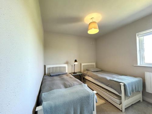 two twin beds in a room with a window at Murlach Moorings in Ballyconneely