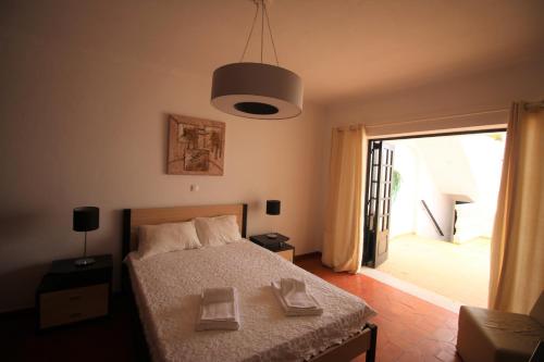 a bedroom with a bed and a door to a balcony at Charming Vila Van Gogh in Luz