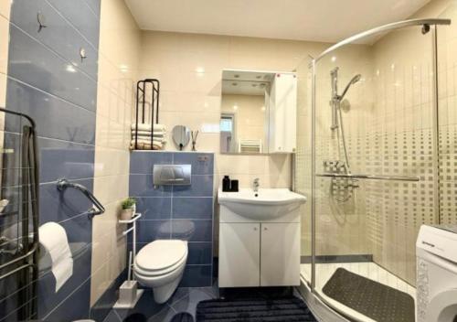 a bathroom with a toilet and a sink and a shower at Hugo s home, apartman blizu bazena i bolnice in Krapinske Toplice