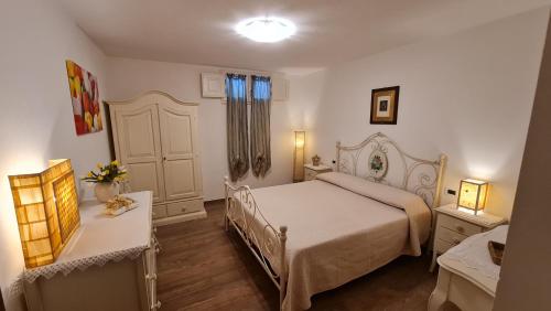 a bedroom with a white bed and a window at Villa Talciona in Poggibonsi