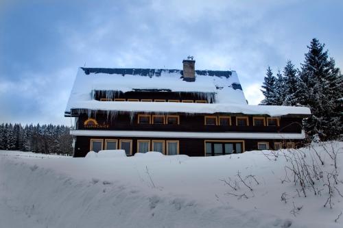 a house covered in snow with snow on top of it at Penzion Slunečnice in Rokytnice nad Jizerou