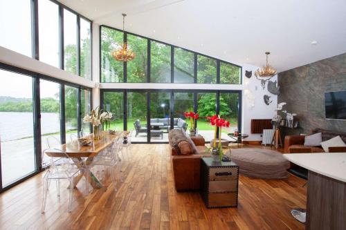 a large living room with large windows and a table at Cameron North Lodge in Balloch