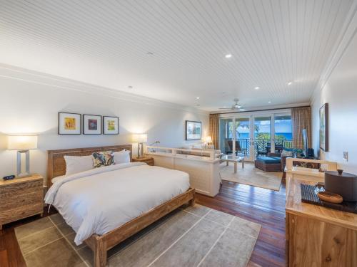 a bedroom with a large bed and a living room at Villa 302 at Turtle Bay in Kahuku