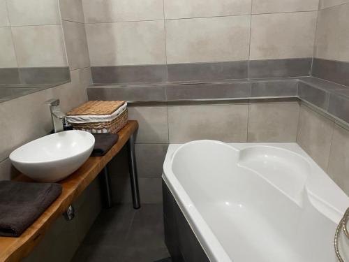 a bathroom with a white tub and a sink at Slnečný byt pri lesoparku in Prievidza