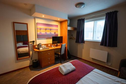 a bedroom with a bed and a desk with a computer at Saram Lodge Lichfield in Lichfield