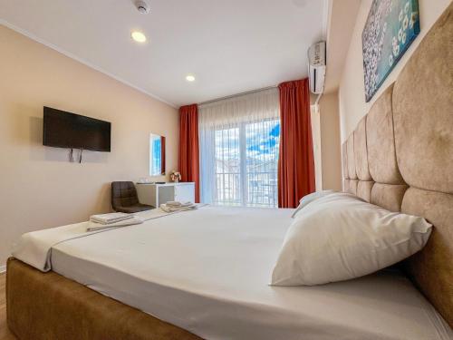 a bedroom with a large white bed with a large window at Pensiunea Riviera in Costinesti