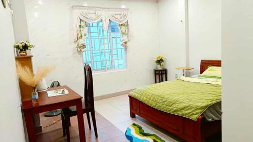 a bedroom with a bed and a desk and a window at Perla Home in Danang
