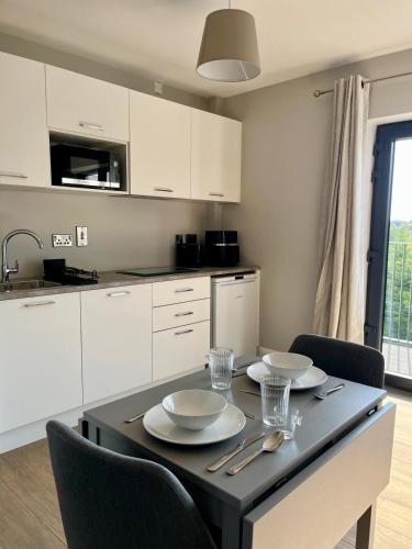 a kitchen with a table with plates and bowls on it at Hawthorn Stays in Maynooth