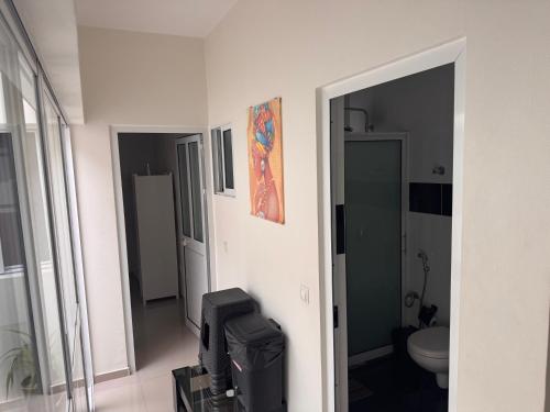 a room with a bathroom with a toilet and a mirror at Bellamy in Porto Novo
