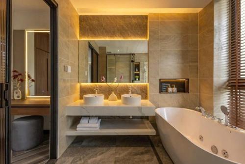 a bathroom with two sinks and a bath tub at AnHuy Villa in Phú Quốc