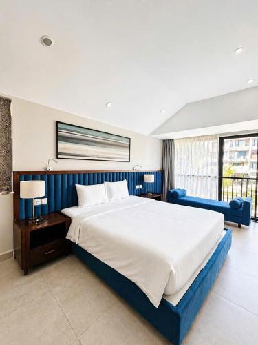 a bedroom with a large bed with a blue headboard at AnHuy Villa in Phú Quốc