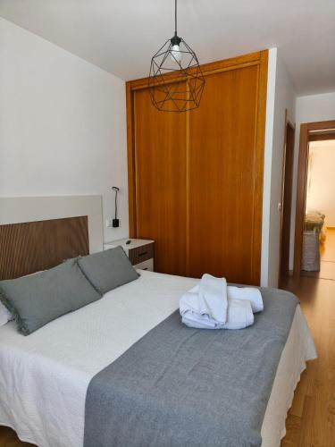 a bedroom with a bed with two towels on it at Piso en Cedeira in Cedeira