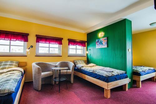 a room with two beds and a table in it at Penzion Slunečnice in Rokytnice nad Jizerou