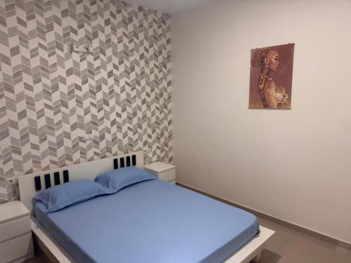 a bedroom with a bed and a painting on the wall at Bellamy in Porto Novo