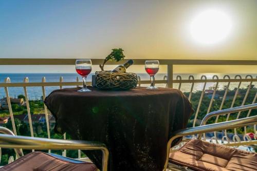 a table with two glasses of wine and a basket of fruit at Beach Oasis by BS- in Agios Gordios