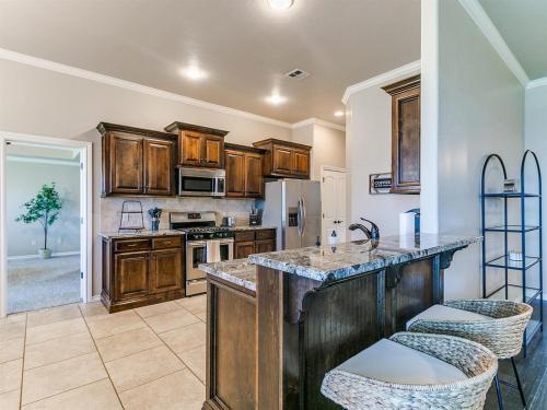 a kitchen with wooden cabinets and a large island with bar stools at Where Comfort Meets Luxury in Yukon